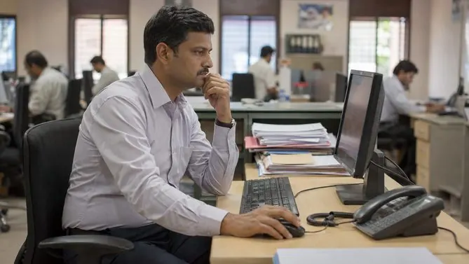 A department head reviewing work at his desk