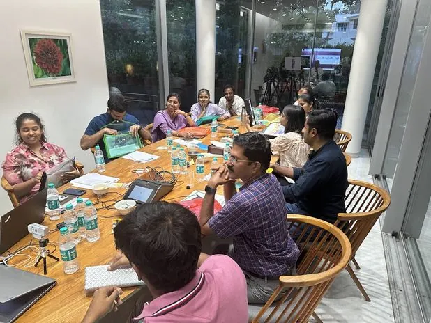 A Poornatha facilitator in discussion with a group of employees