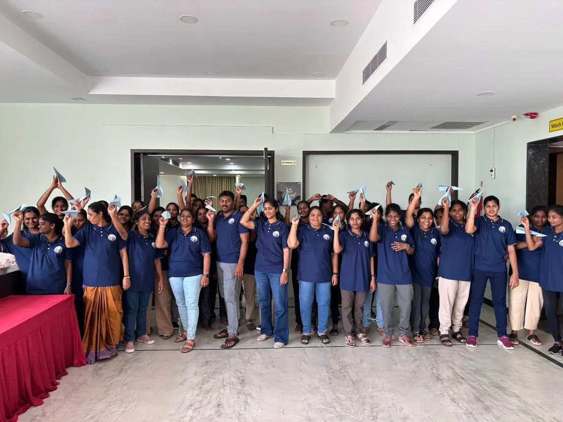 A large group of programme participants celebrating together at the end of a session